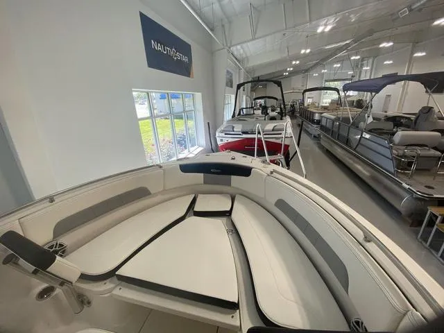 Slide: The Image of 2024 Robalo R222EX boat interior in showroom, featuring spacious seating and modern design. - 13