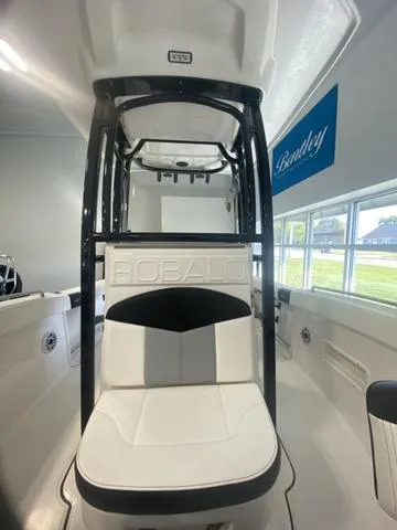 Slide: The Image of 2024 Robalo R222EX boat interior with seating and console, displayed indoors. - 14