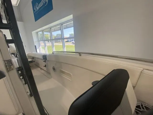 Slide: The Image of 2024 Robalo R222EX boat interior with seating, displayed in a showroom. - 15