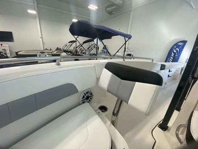 Slide: The Image of 2024 Robalo R222EX boat interior with seating and speaker in showroom. - 17