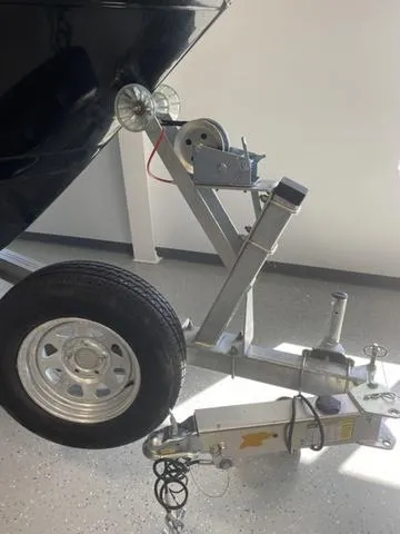 Slide: The Image of 2024 Robalo R222EX boat trailer with wheel and hitch in a showroom. - 2