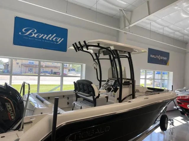 Slide: The Image of 2024 Robalo R222EX boat displayed in showroom with Bentley and NauticStar banners. - 4