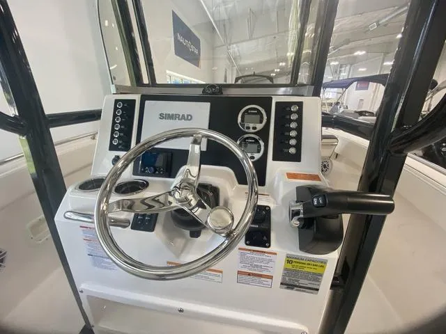 Slide: The Image of 2024 Robalo R222EX boat dashboard with steering wheel and Simrad navigation system. - 9