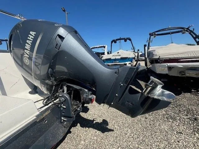 Slide: The Image of 2021 Robalo R222 boat with Yamaha outboard motor, parked on gravel under clear blue sky. - 22