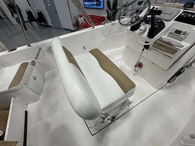 Slide: The Image of 2019 Edgewater 170CC boat interior with white and tan seating, steering wheel, and control panel. - 11