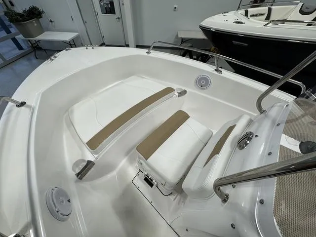 Slide: The Image of 2019 Edgewater 170CC boat interior with white and tan seating in showroom. - 18