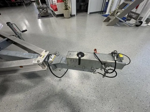 Slide: The Image of Trailer hitch of a 2019 Edgewater 170CC boat on a showroom floor. - 19