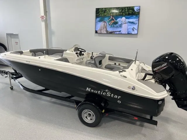 Slide: The Image of 2023 NauticStar 203 SC boat with Mercury engine on display indoors. - 3