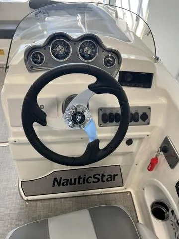 Slide: The Image of 2024 NauticStar 203 SC boat dashboard with steering wheel and gauges. - 10
