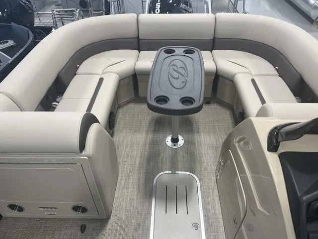 Slide: The Image of 2025 Bentley Pontoons 223 Swingback interior with beige seating and central table. - 3