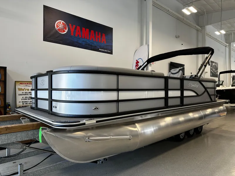 Slide: The Image of 2025 Bentley Pontoons 223 NAVIGATOR in showroom, featuring sleek design and Yamaha branding. - 1