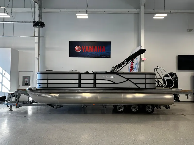Slide: The Image of 2025 Bentley Pontoons 223 NAVIGATOR pontoon boat displayed indoors with Yamaha signage. - 2
