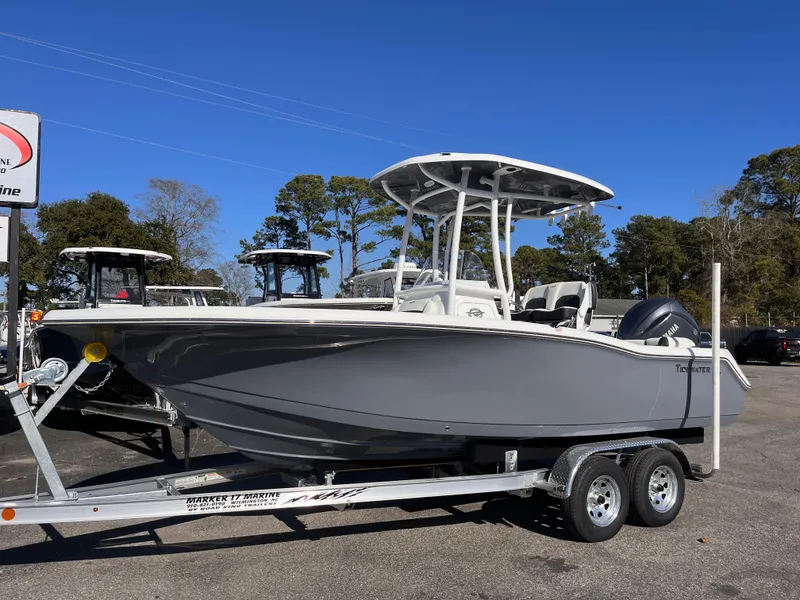 Slide: The Image of 2025 Tidewater 210 LXF boat on trailer, parked outdoors, under clear blue sky. - 1