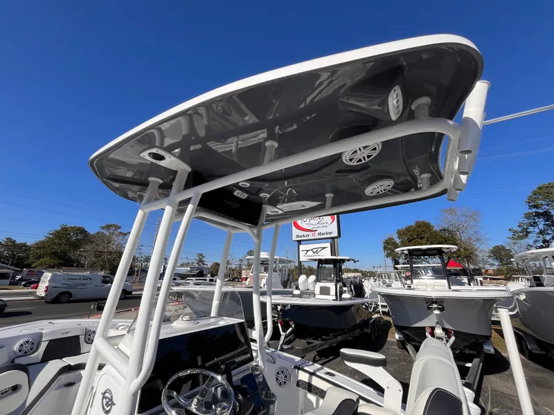 Slide: The Image of 2025 Tidewater 210 LXF boat with T-top and steering console, displayed outdoors. - 14