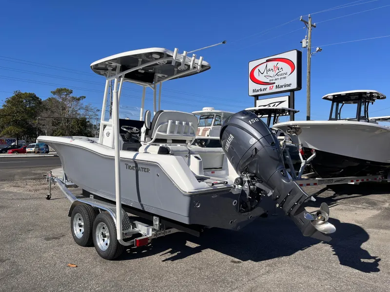 Slide: The Image of 2025 Tidewater 210 LXF boat on trailer, displayed at a marina under clear blue sky. - 2