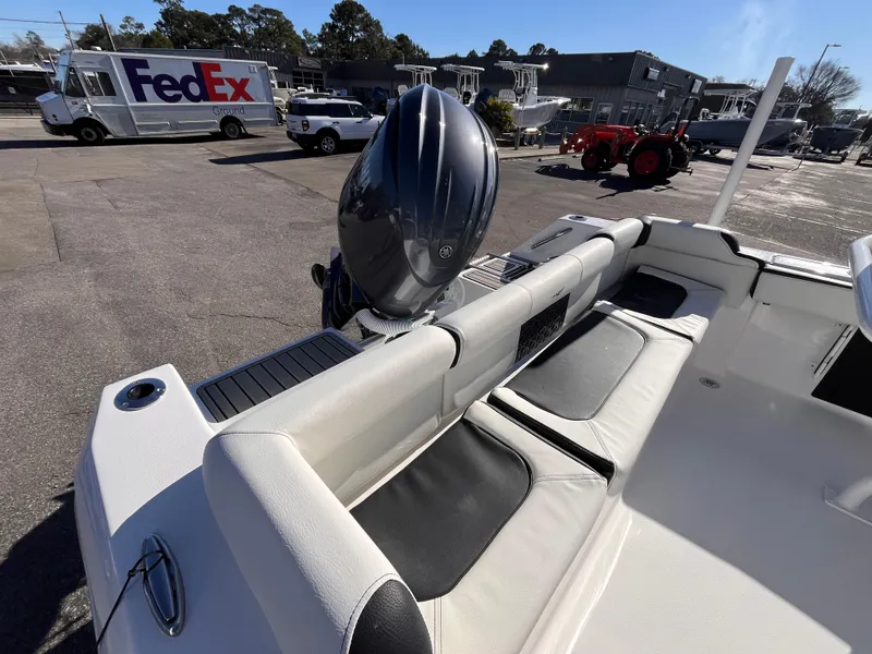 Slide: The Image of 2025 Tidewater 210 LXF boat interior with seating, parked near FedEx truck. - 4