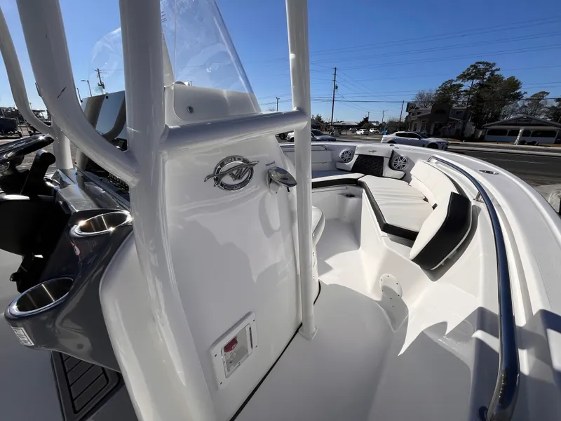 Slide: The Image of 2025 Tidewater 210 LXF boat interior with seating and console, under clear blue sky. - 8