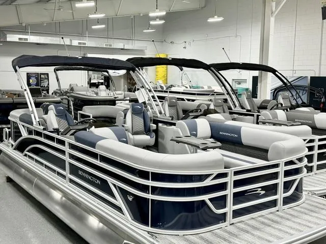 Slide: The Image of 2025 Bennington 23 SSR pontoon boats displayed in a showroom with modern seating. - 7