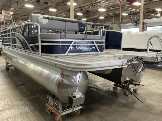 Slide: The Image of 2025 Bennington 23 SSB pontoon boat in a warehouse setting. - 10