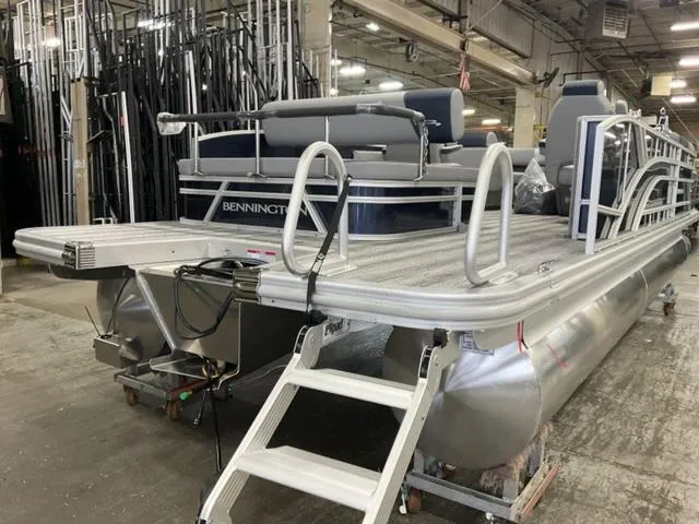 Slide: The Image of 2025 Bennington 23 SSB pontoon boat in a warehouse, featuring sleek design and modern amenities. - 11