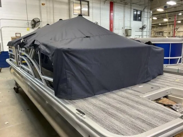 Slide: The Image of 2025 Bennington 23 SSB pontoon boat with cover in a warehouse setting. - 17