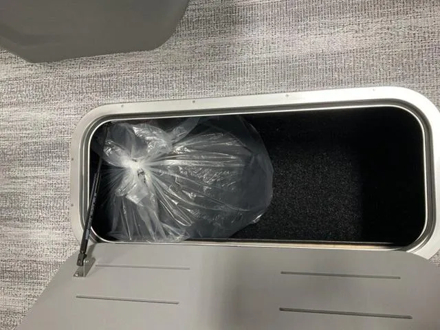 Slide: The Image of Storage compartment in 2025 Bennington 22 SSR boat with a plastic bag inside. - 11