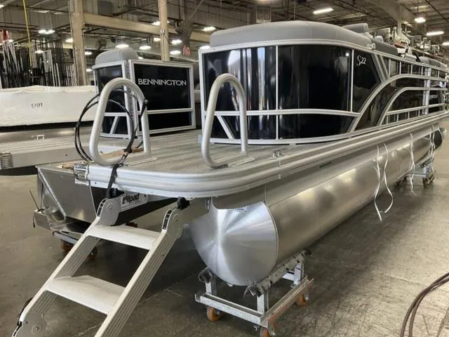 Slide: The Image of 2025 Bennington 22 SSR pontoon boat in a showroom, featuring sleek design and sturdy construction. - 14
