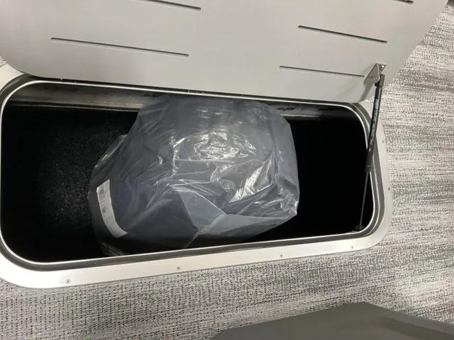 Slide: The Image of Storage compartment in a 2025 Bennington 22 SSB boat, containing a covered item. - 11