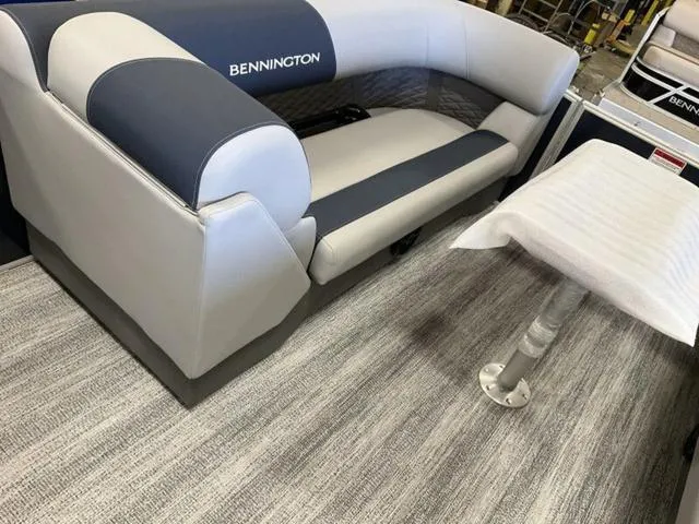 Slide: The Image of 2025 Bennington 22 SSB boat interior with gray and blue seating and carpeted flooring. - 5