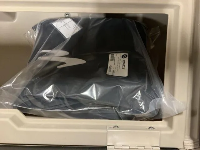 Slide: The Image of 2025 Bennington 23 SL storage compartment with packaged item inside. - 10