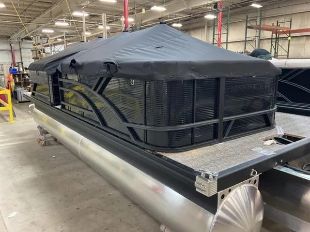 Slide: The Image of 2025 Bennington 23 SL pontoon boat with cover in a warehouse setting. - 13