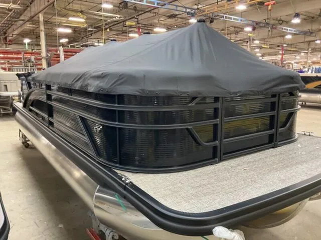 Slide: The Image of 2025 Bennington 23 SL pontoon boat with cover in a factory setting. - 14