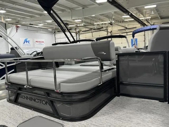 Slide: The Image of 2025 Bennington 23 SSB pontoon boat interior with gray seating in a showroom. - 23
