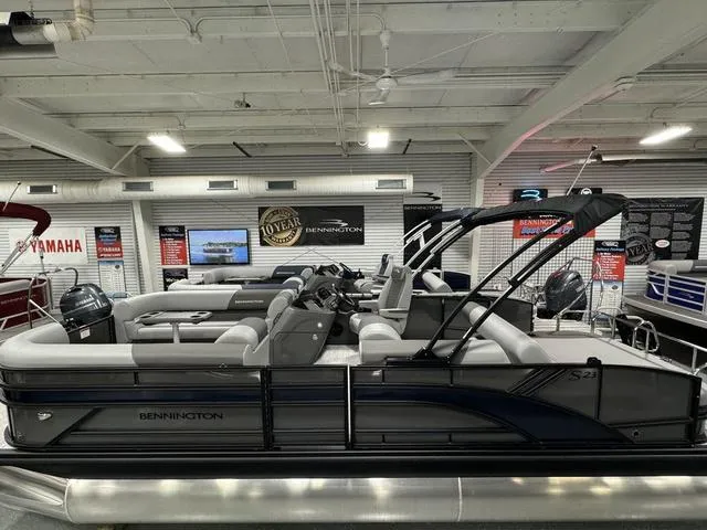Slide: The Image of 2025 Bennington 23 SSB pontoon boat in showroom, featuring sleek design and modern amenities. - 5