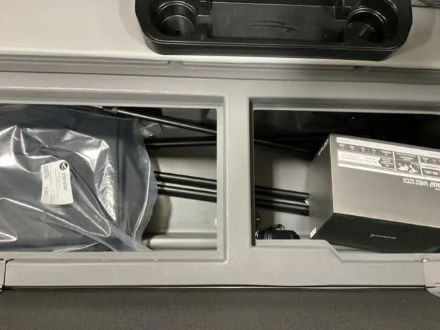 Slide: The Image of Storage compartment in a 2025 Bennington 23 SSB boat, containing packaged items and accessories. - 14