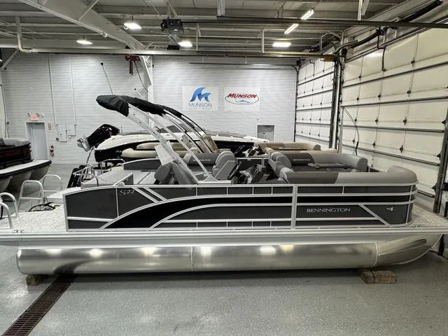 Slide: The Image of 2025 Bennington 22 SSB pontoon boat in showroom, sleek design, black and silver accents. - 4