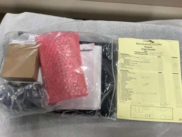 Slide: The Image of Package contents with Bennington 22 SSR 2025 checklist and wrapped items on a table. - 11