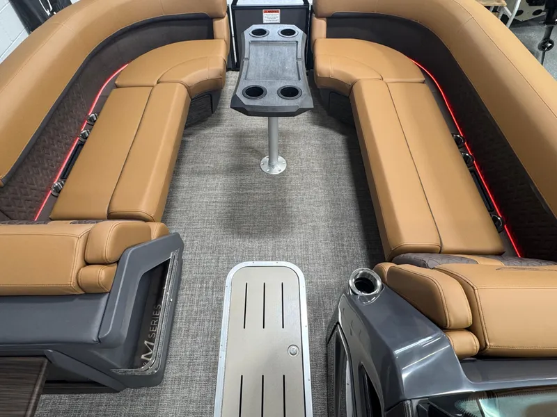Slide: The Image of 2025 Bennington M Swingback 24 MSB interior with tan seating and central table. - 18