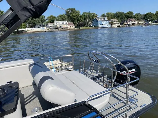 Slide: The Image of 2021 Sylvan L-3 DLZ pontoon boat on a lake with Mercury outboard motor. - 12