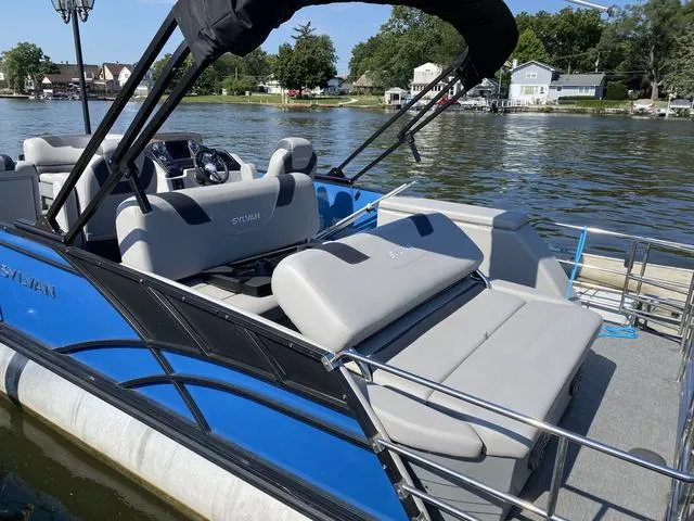 Slide: The Image of 2021 Sylvan L-3 DLZ pontoon boat with gray seating on a lake. - 13
