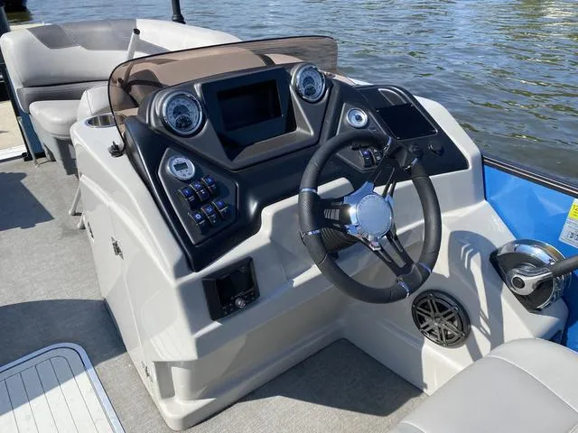 Slide: The Image of 2021 Sylvan L-3 DLZ boat dashboard with steering wheel and controls on water. - 8