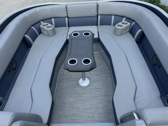Slide: The Image of 2022 Bennington 25 LTSB boat interior with gray seating and central table. - 13
