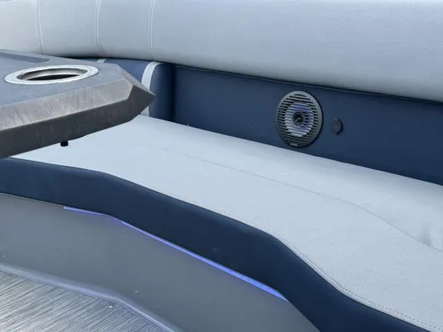 Slide: The Image of 2022 Bennington 25 LTSB boat interior with cushioned seating and speaker. - 25