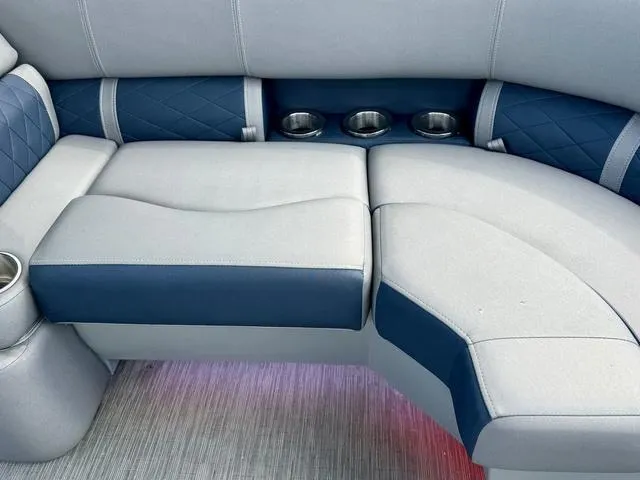 Slide: The Image of 2022 Bennington 25 LTSB boat seating with cup holders, featuring blue and gray upholstery. - 32