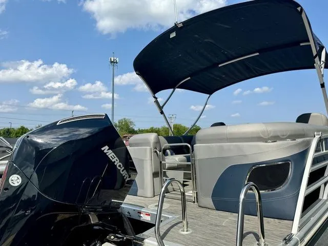 Slide: The Image of 2022 Bennington 25 LTSB pontoon boat with Mercury engine and canopy under blue sky. - 33