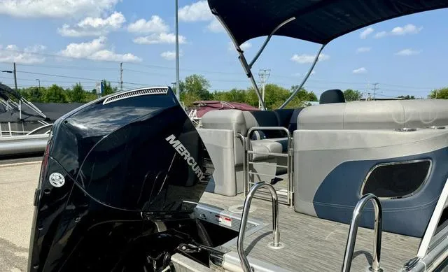 Slide: The Image of 2022 Bennington 25 LTSB pontoon boat with Mercury outboard motor, under a sunny sky. - 34