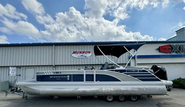 Slide: The Image of 2022 Bennington 25 LTSB pontoon boat parked outside a building under a cloudy sky. - 5