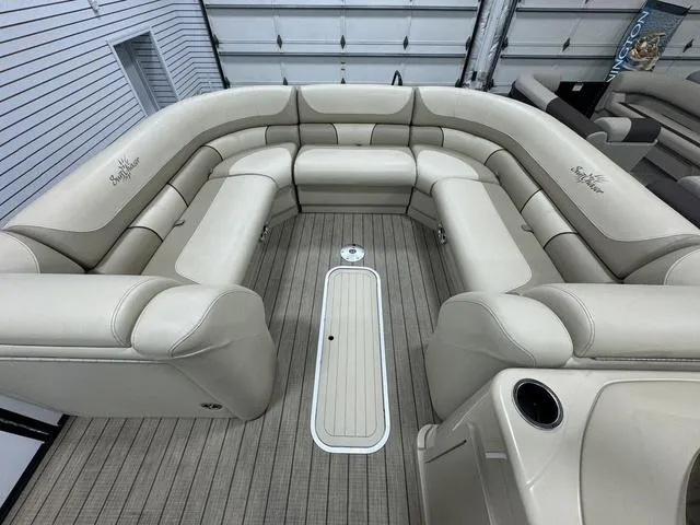 Slide: The Image of 2019 SunChaser 8525 Entertainer boat interior with beige seating and wood-patterned flooring. - 17