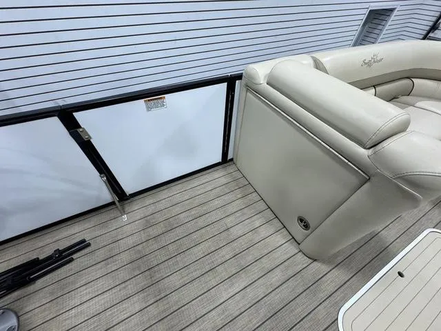 Slide: The Image of 2019 SunChaser 8525 Entertainer boat interior with beige seating and wood-patterned flooring. - 19