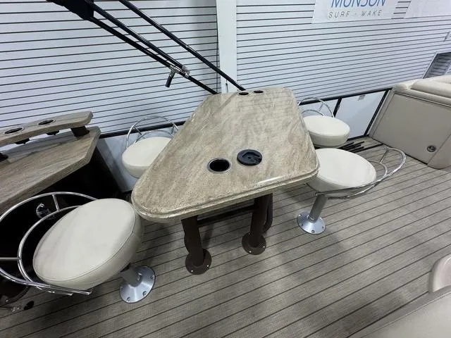 Slide: The Image of 2019 SunChaser 8525 Entertainer boat interior with table and swivel chairs. - 2